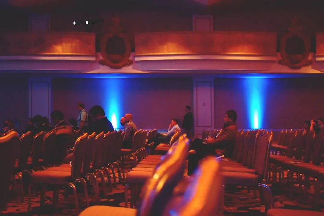 Conference hall with the audience seated in front of a lit stage