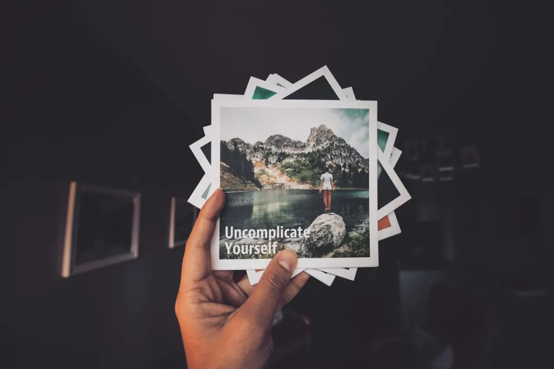 A hand holding a fan of photo prints