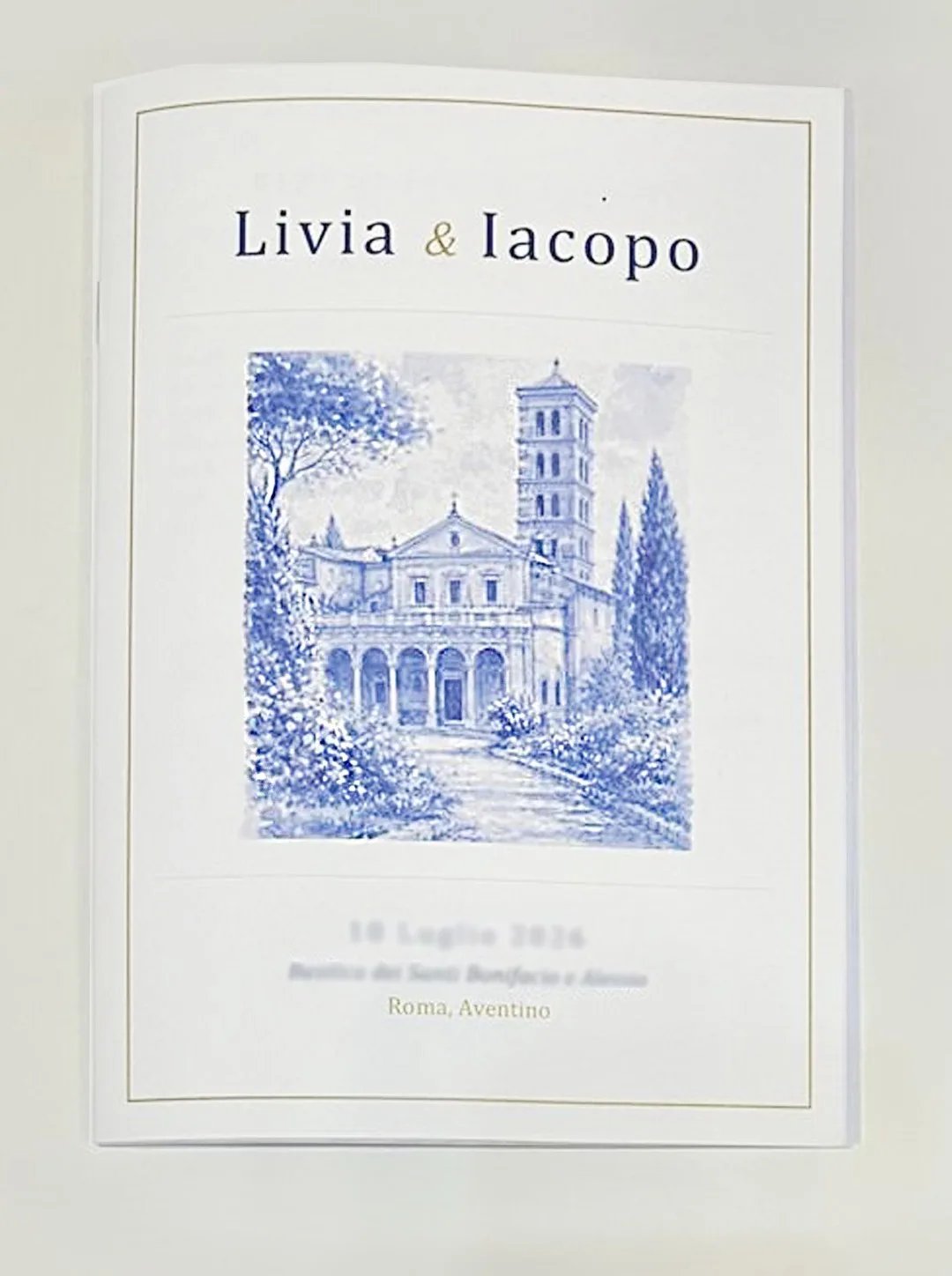 Wedding mass booklet printed and bound by GUUG for a wedding in Rome: ivory cover with a watercolour illustration of a Roman basilica and gold details