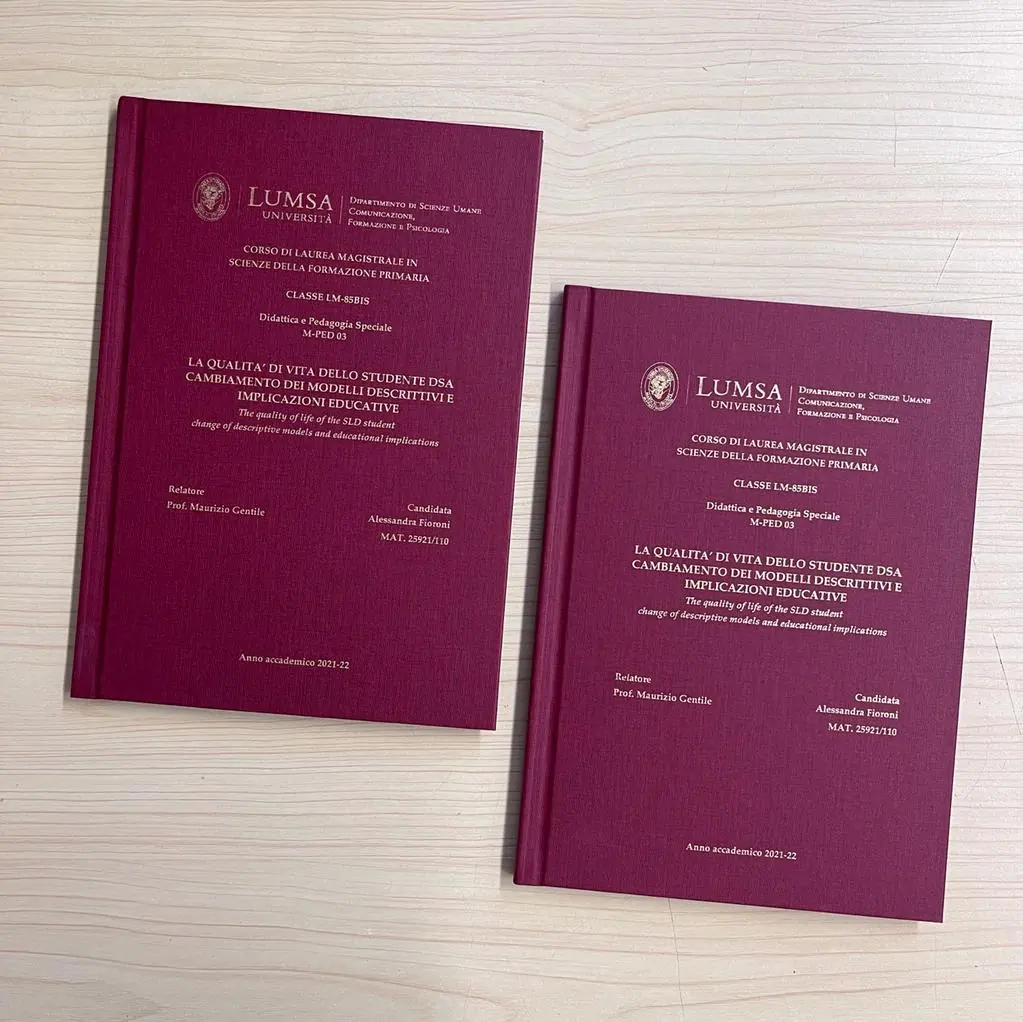 Due tesi di laurea con copertina rigida bordeaux e stampa foil oro, rilegate da GUUG per la LUMSA di Roma