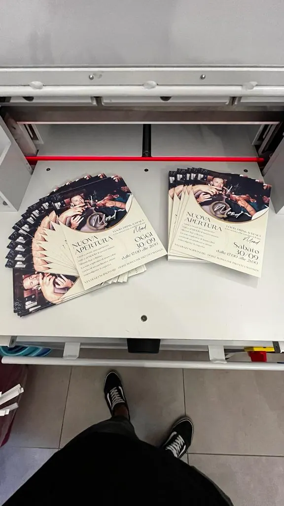 Grand Opening flyers printed by GUUG for the Mood bar in Rome, coming out of the digital press, double-sided on coated paper